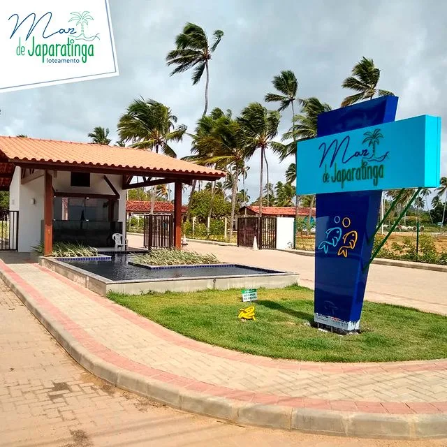 Entrada do Mar de Japaratinga com letreiro azul e portaria